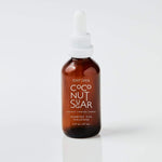 small bottle of coconut sugar scented oil on a white background