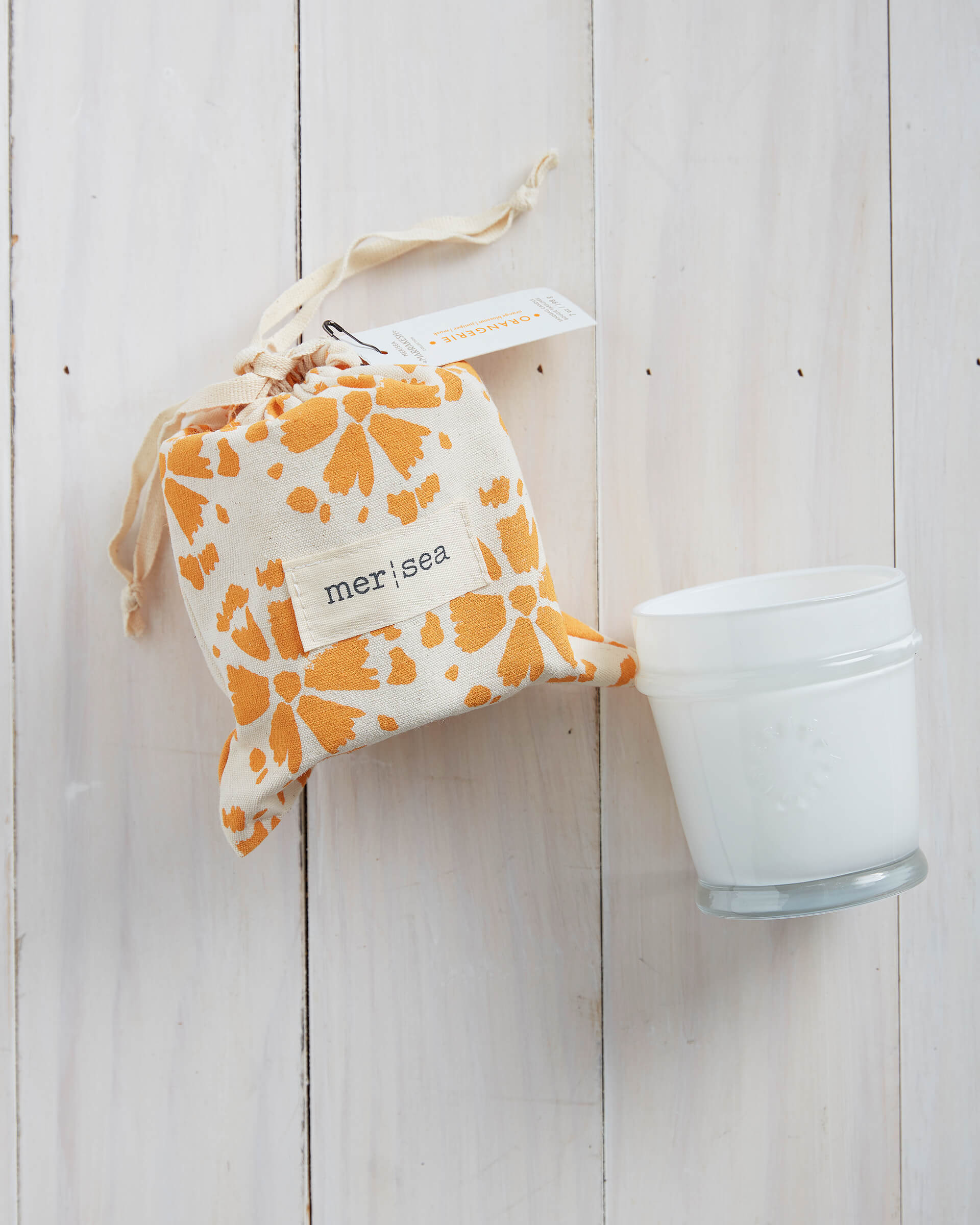 7 oz orange orangerie canister candle with the lid open on a white background 