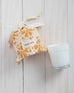 7 oz orange orangerie canister candle with the lid open on a white background 