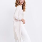 female wearing off white kimono sweater standing sideways on a white background