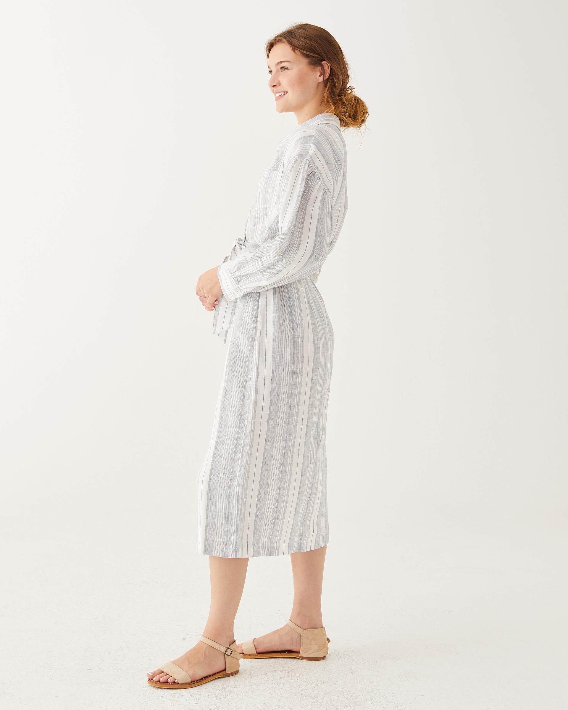 female wearing linen striped collared dress with belt and front button sideways on white background
