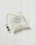 white draw string bag with brown, grey and white wool dryer balls inside on a white background 