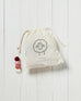 white draw string bag with red, white and pink wool dryer balls inside on a white background 