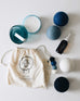 collection of wool dryer balls a white draw string bag a voyaguer canister candle and scented oil 