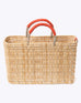 medium straw basket wrapped with orange leather handle on a white background