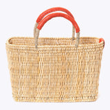 small straw basket wrapped with orange leather handle on a white background 