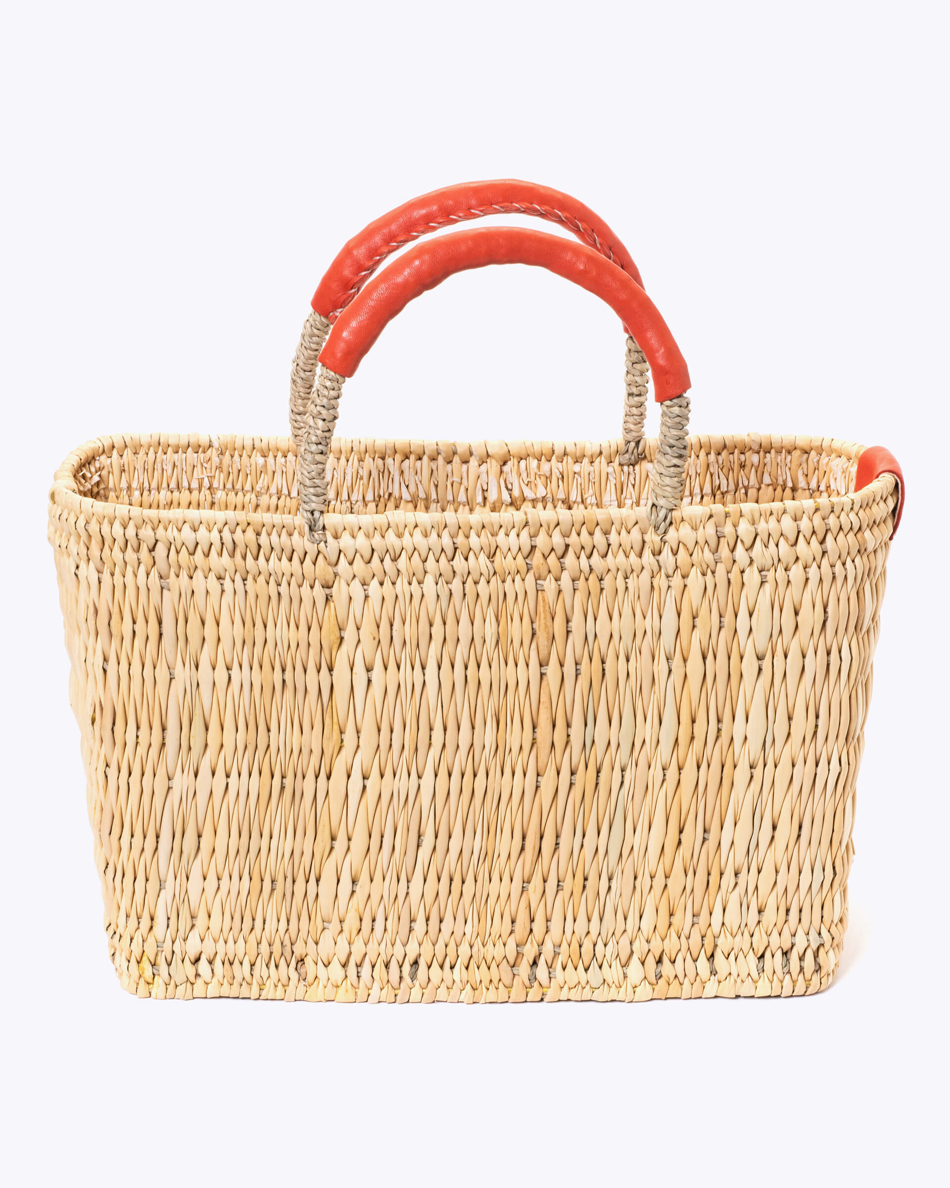 small straw basket wrapped with orange leather handle on a white background 