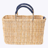 small straw basket wrapped with dark blue leather handle on a white background 