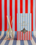 OUI! reed diffuser boxed in red, blue and white stripes on red, blue and white striped background 