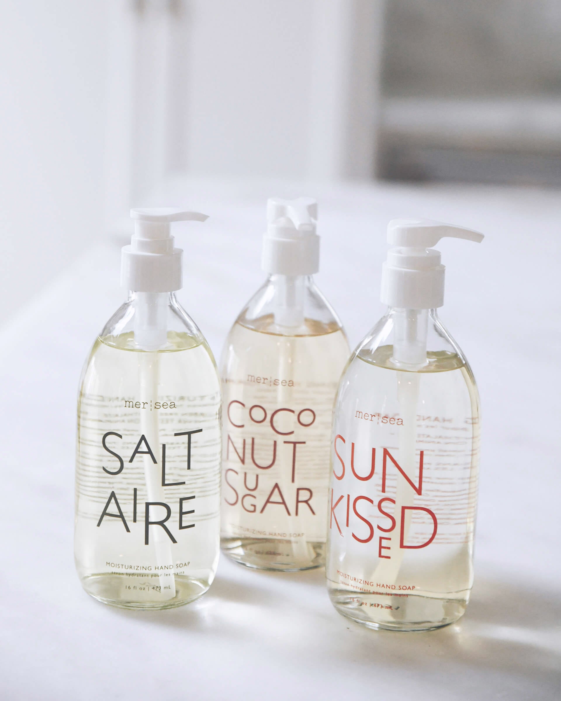 coconut sugar, saltaire, and sun kissed large liquid hand soaps sitting on a counter in a kitchen
