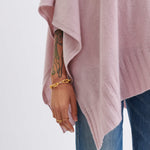 close up of female wearing light pink wrap focused on the bottom rib hemline on white background