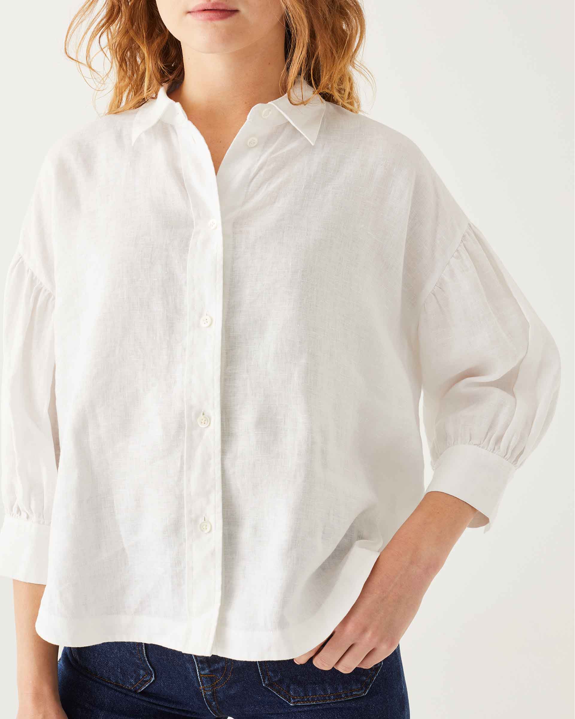 front detail of female wearing white linen shirt with button-down and collar on white background
