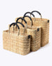 small, medium, large straw basket wrapped with black leather handles on white background