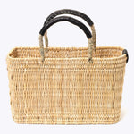 small straw basket wrapped with black leather handle on a white background