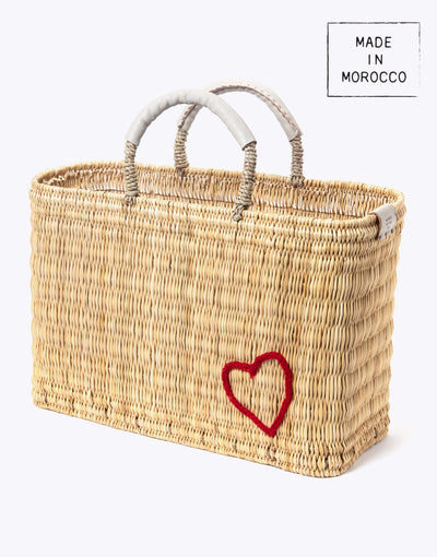 medium red heart straw basket wrapped with neutral leather handle on a white background at an angle