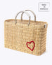 medium red heart straw basket wrapped with neutral leather handle on a white background at an angle