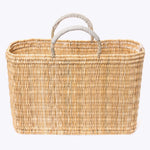large straw basket wrapped with neutral leather handle on a white background 