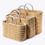 small, medium, large straw basket wrapped with neutral colored leather handles on white background