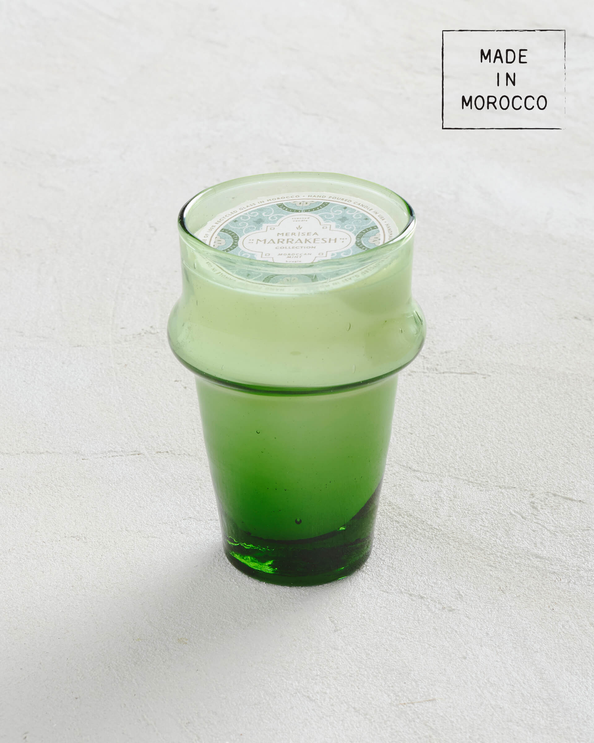 tall green glass moroccan mint candle sitting on a white background made in morocco 