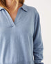 close up of female wearing light blue collared v-neck sweater on a white background