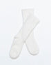 pair of white fuzzy socks with rib knit details on a white background 