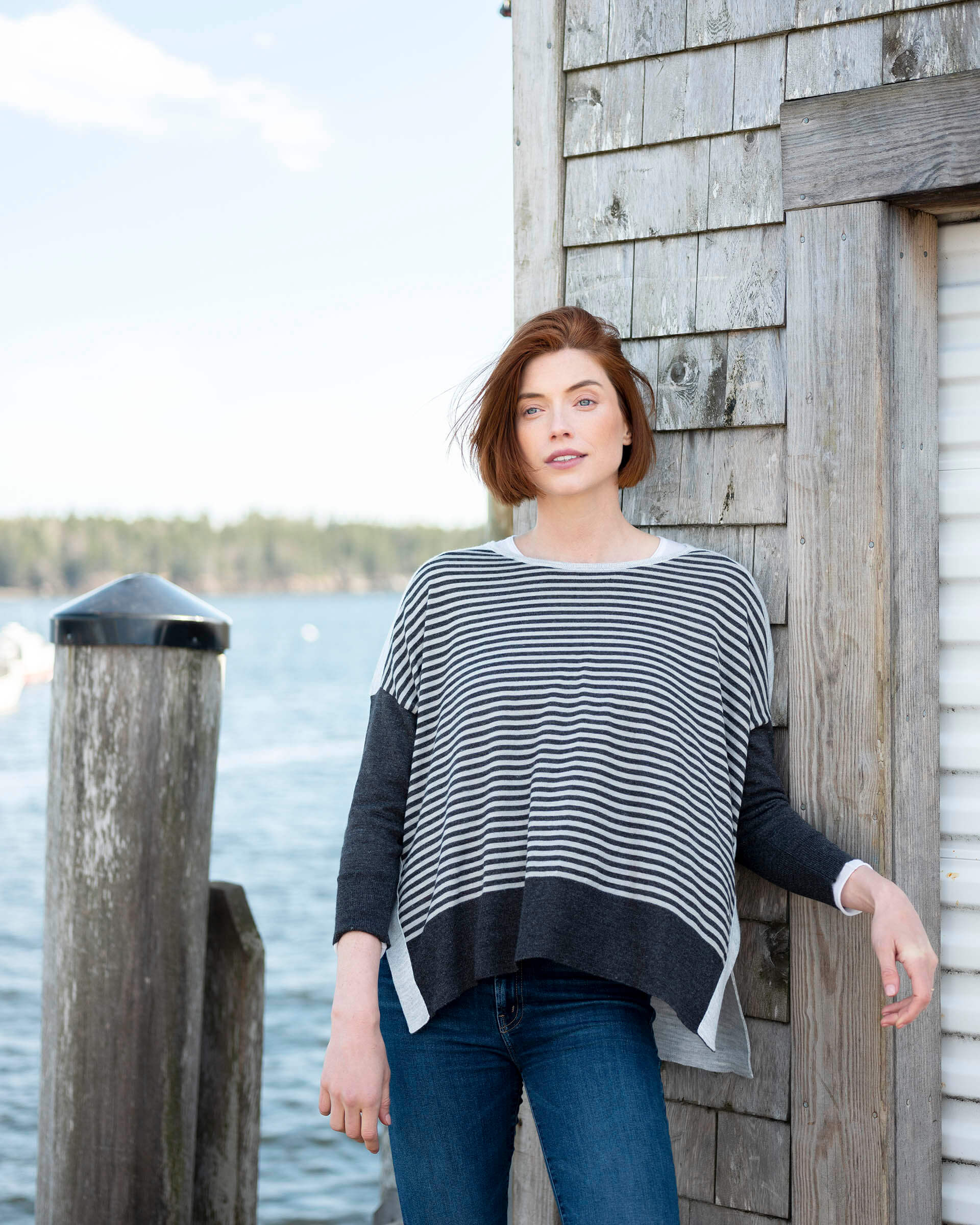 woman at boathouse wearing Amour Sweater in grey stripes with heart elbow patch