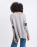 rearview of woman wearing Amour Sweater in Grey and navy heart elbow patch