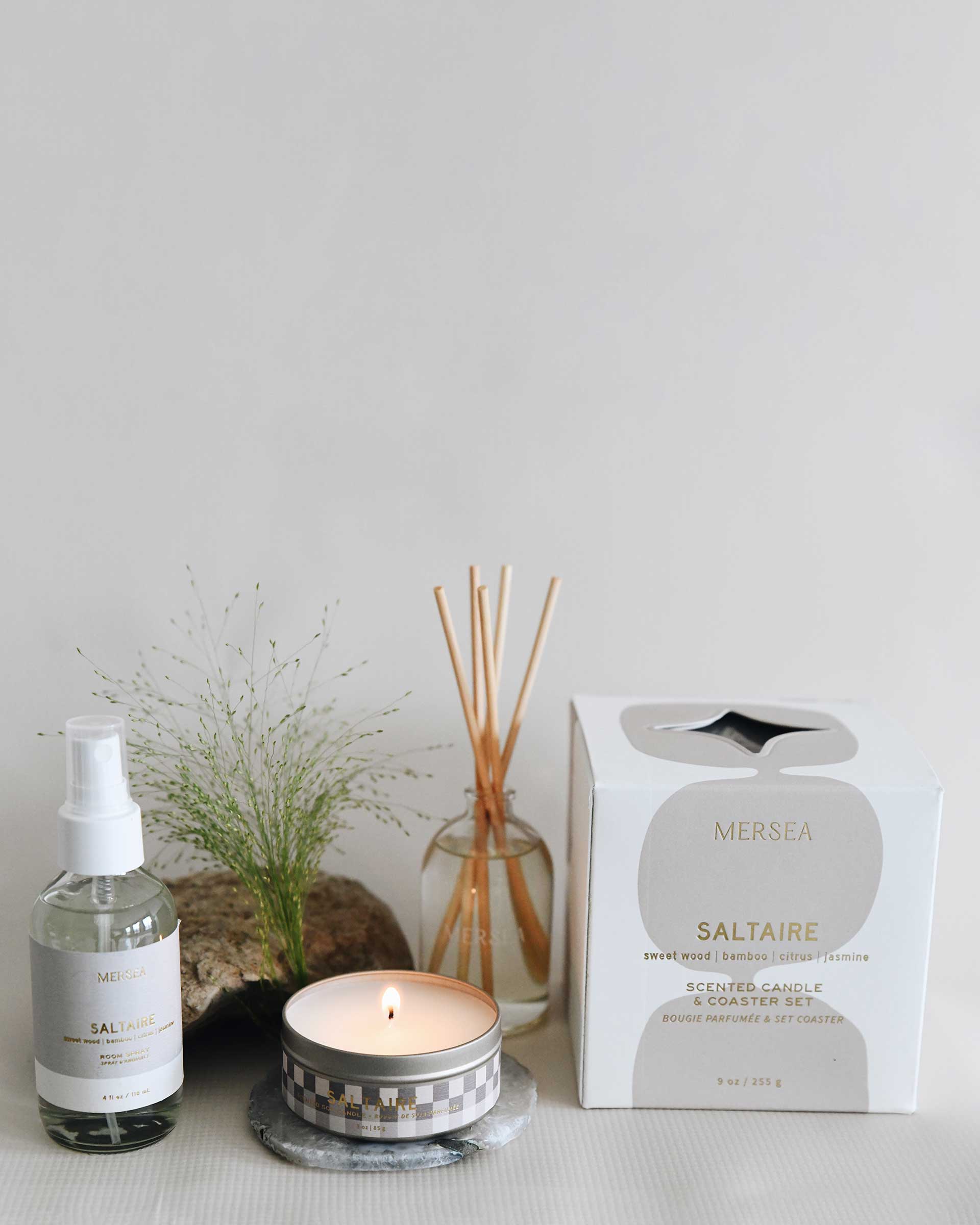 saltaire diffuser, candles, room spray, rock and greenery on a grey background