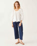 woman wearing white mersea ada poplin top with puff sleeves standing with white background
