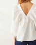 rearview of woman wearing white mersea ada poplin top with puff sleeves standing with white background