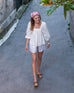 woman wearing white mersea ada poplin top with puff sleeves walking in street