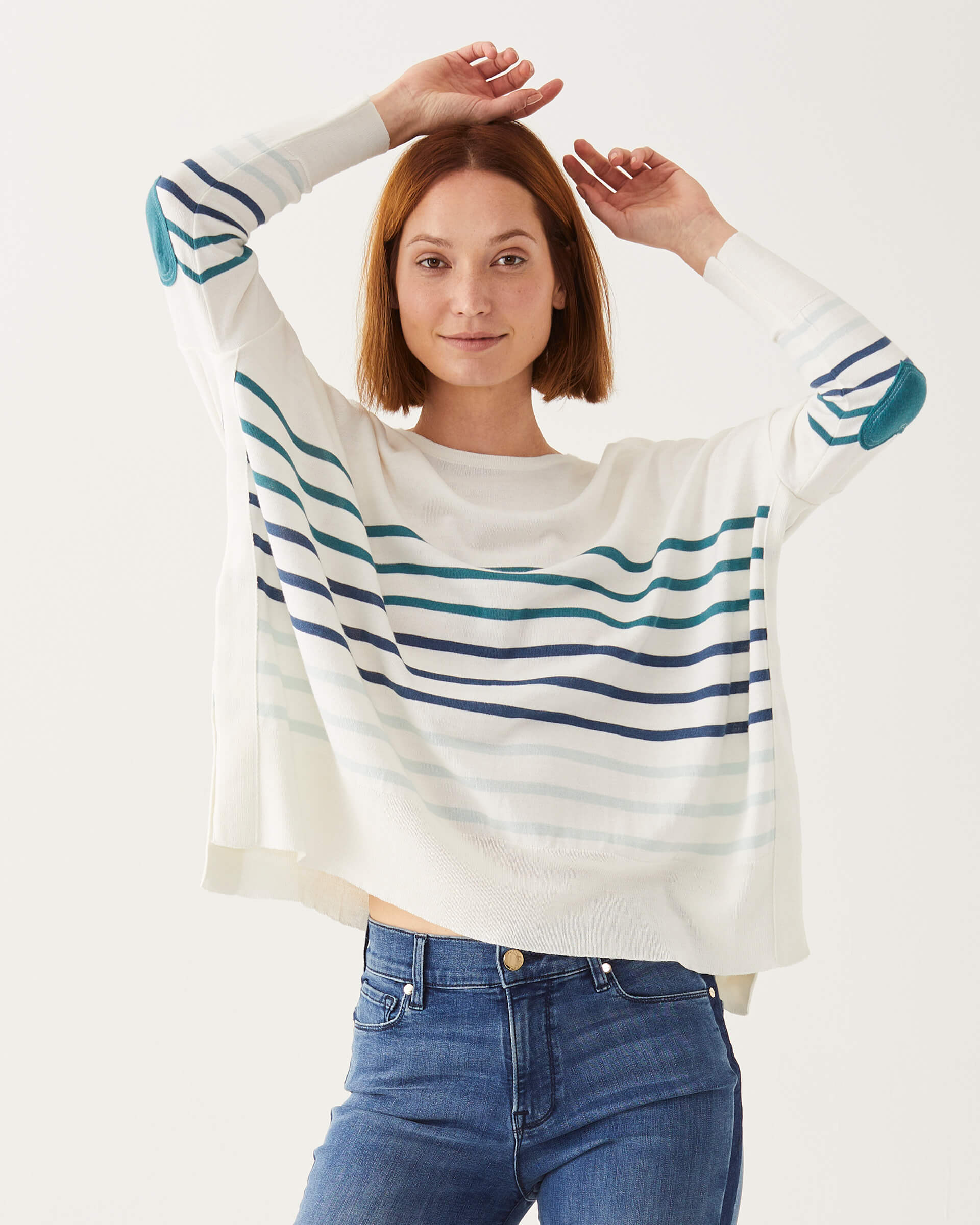 female wearing white and blue stripe sweater with heart elbow patch arms raised on white background