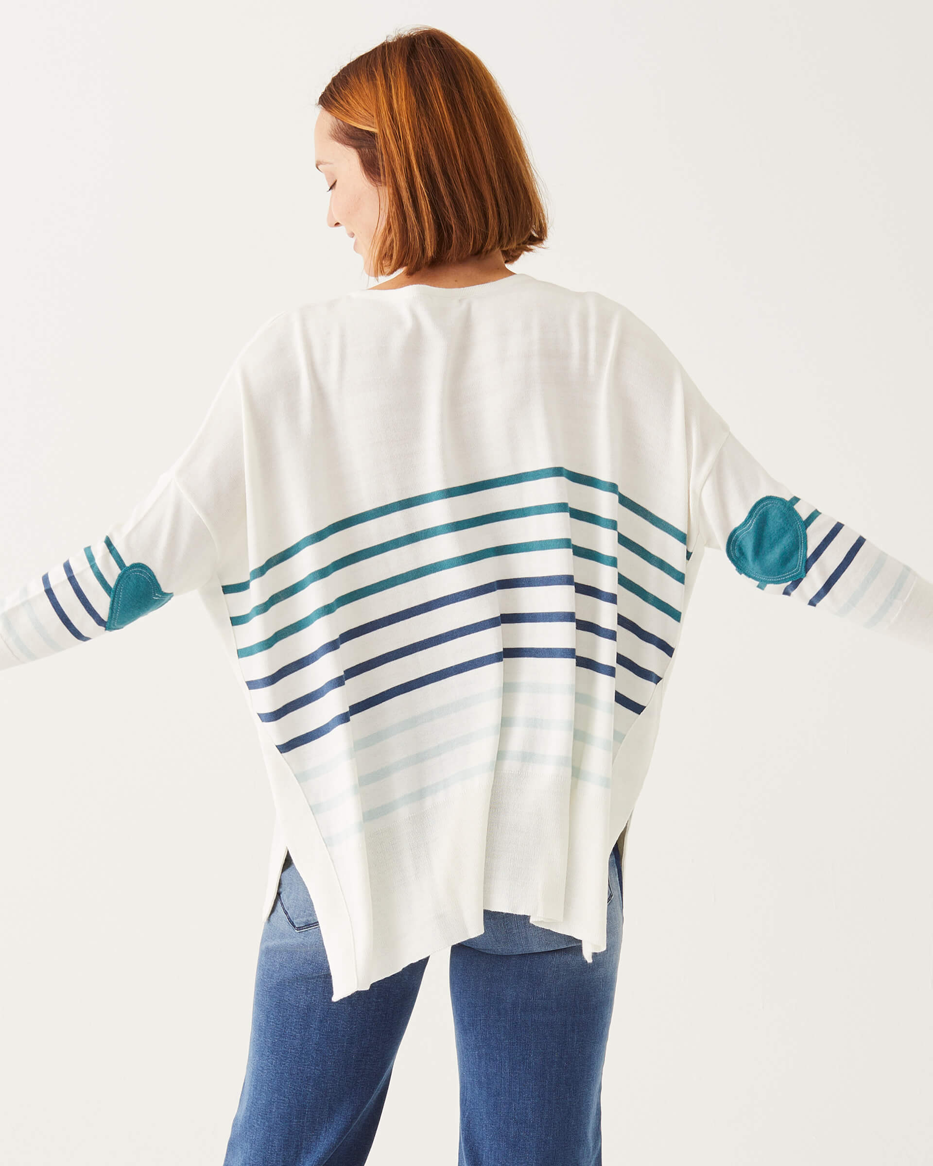 female wearing white and blue striped sweater with heart elbow patch backwards on white background
