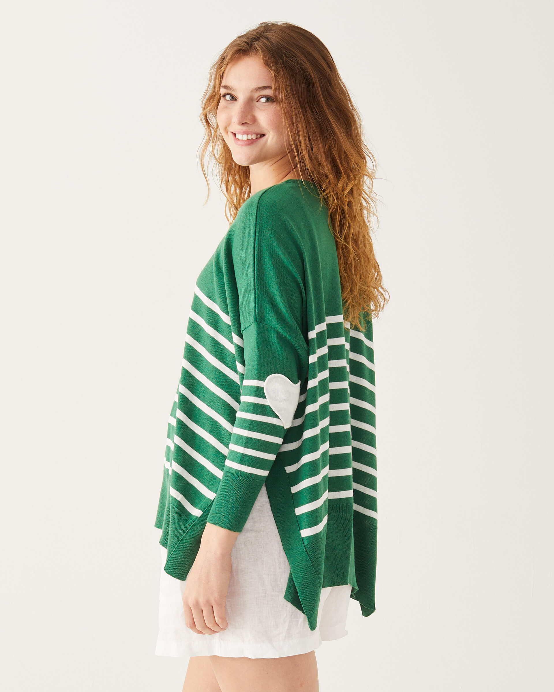 close up of female wearing green and white striped sweater with white heart on the elbow 