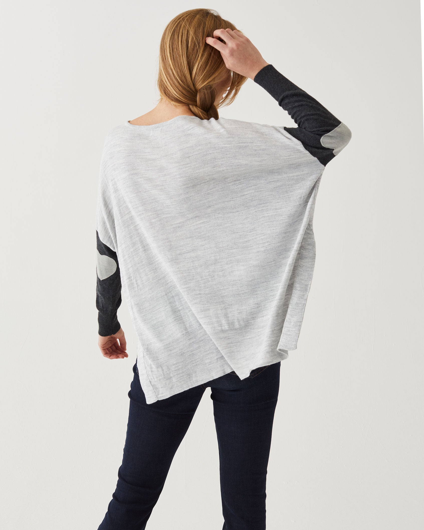 rearview of woman wearing Amour Sweater in grey stripes with grey heart elbow patch