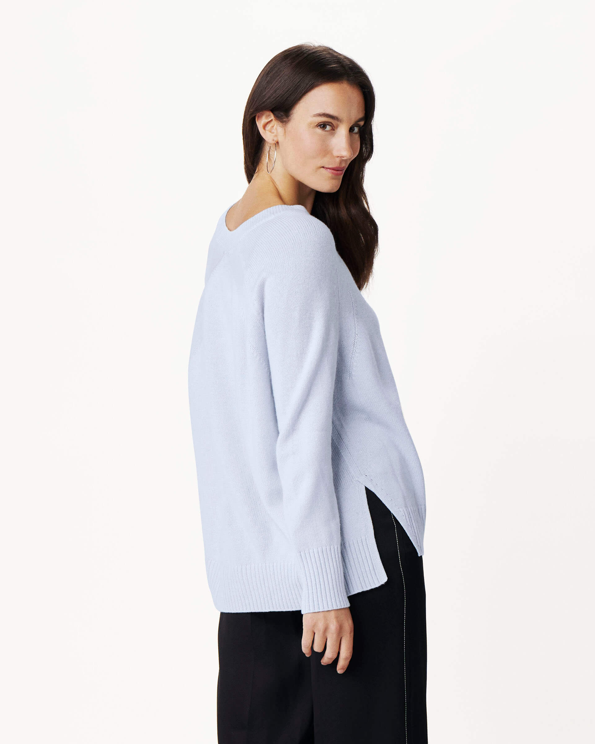 side view of woman wearing mersea banff cashmere sweater in icy blue color