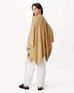 female wearing golden brown cable knit wrap turned around on a white background