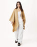 female wearing golden brown cable knit wrap with a hand in a pocket on a white background