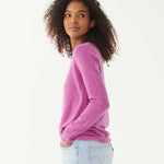 female wearing purple fitted cashmere sweater with a crewneck sideways on a white background