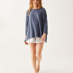female wearing dark blue tee-shirt with three-quarter sleeves walking on a white background
