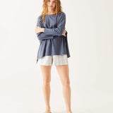 female wearing dark blue tee-shirt with three-quarter sleeves with arms crossed on white background