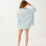 female wearing light blue cotton tee shirt with split sides backwards on white background