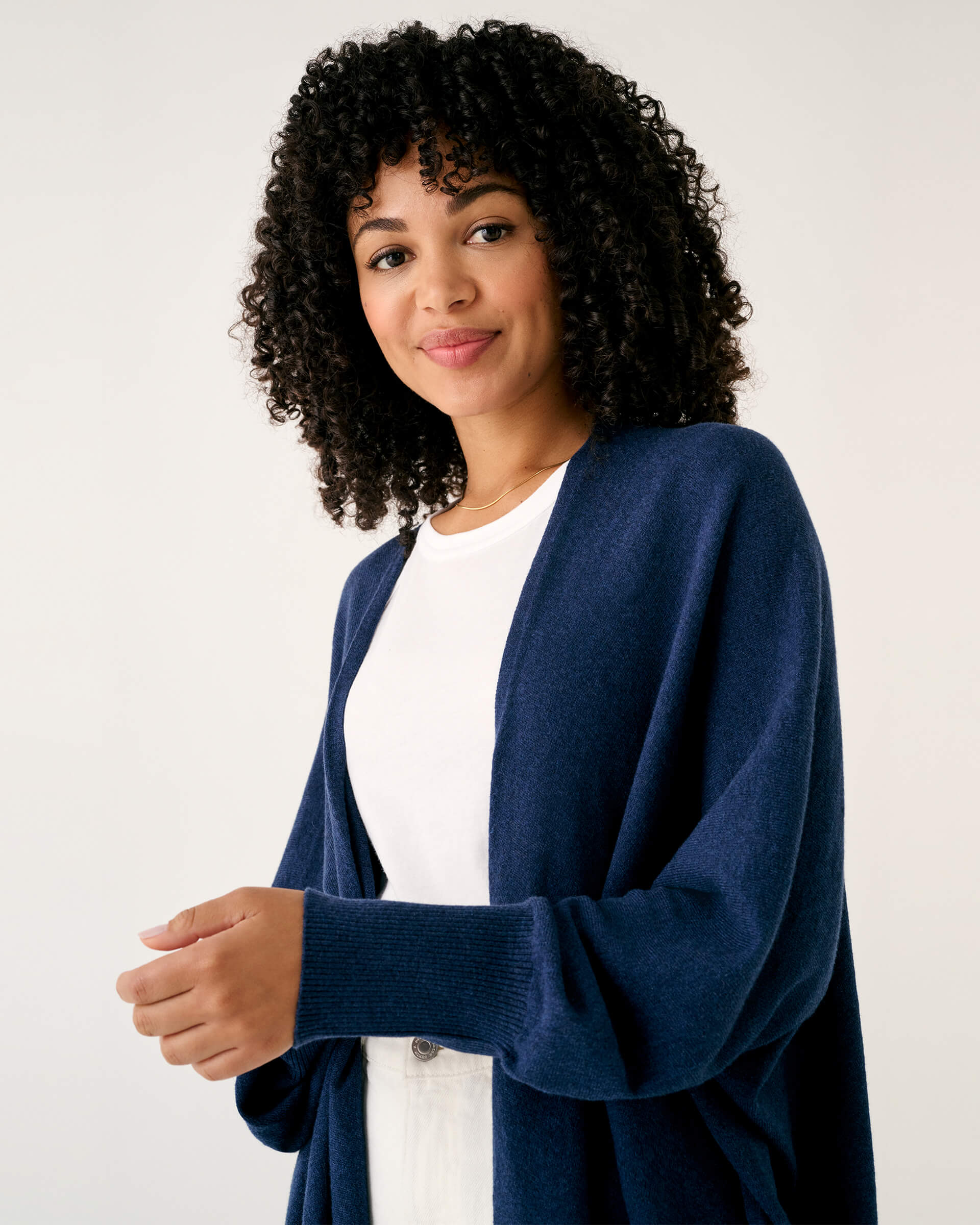 close up of female wearing dark blue kimono sweater on a white background