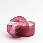 7 oz dark pink coconut sugar canister candle with the lid open on a white background