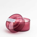 7 oz dark pink coconut sugar canister candle with the lid open on a white background