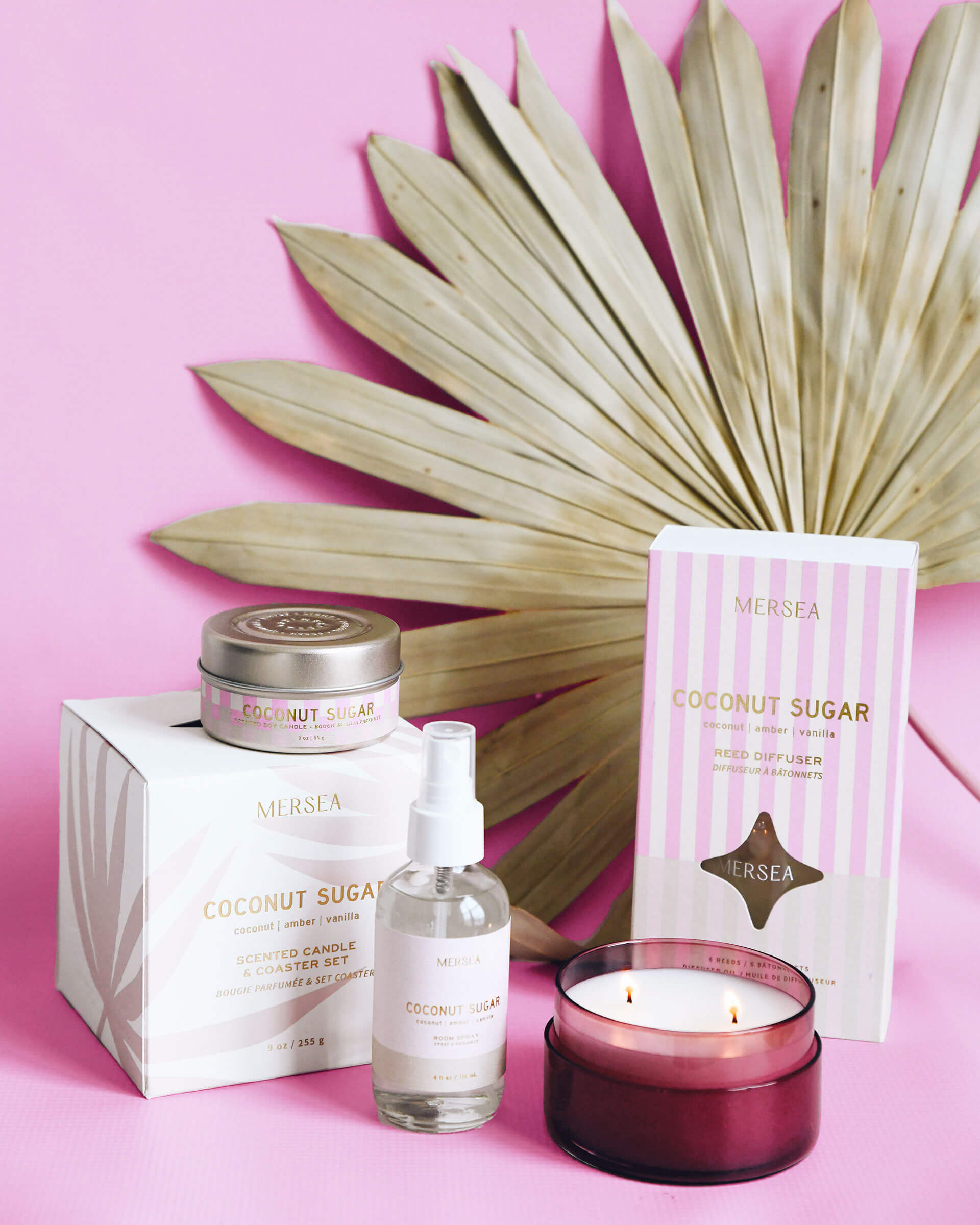 Coconut Sugar scented collection of candles, diffuser and room spray in front of pink background