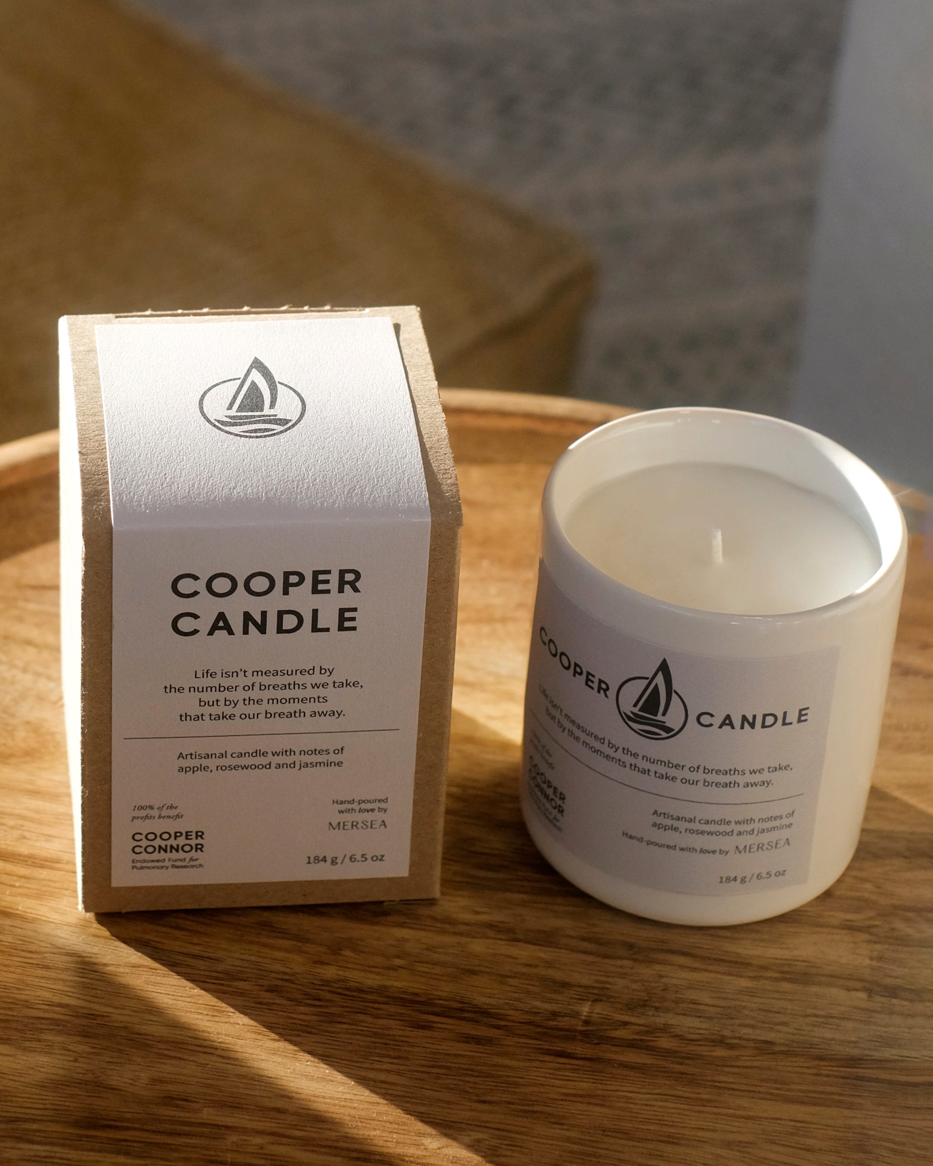 white ceramic cooper candle and box sitting on brown wooden side table 