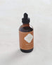 small bottle of dune scented oil burner with brown marrakesh label on white background