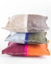 three different colored felt wool pillows stacked on top of eachother on a white background