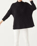 close up of female wearing black mock neck sweater dancing on a white background 